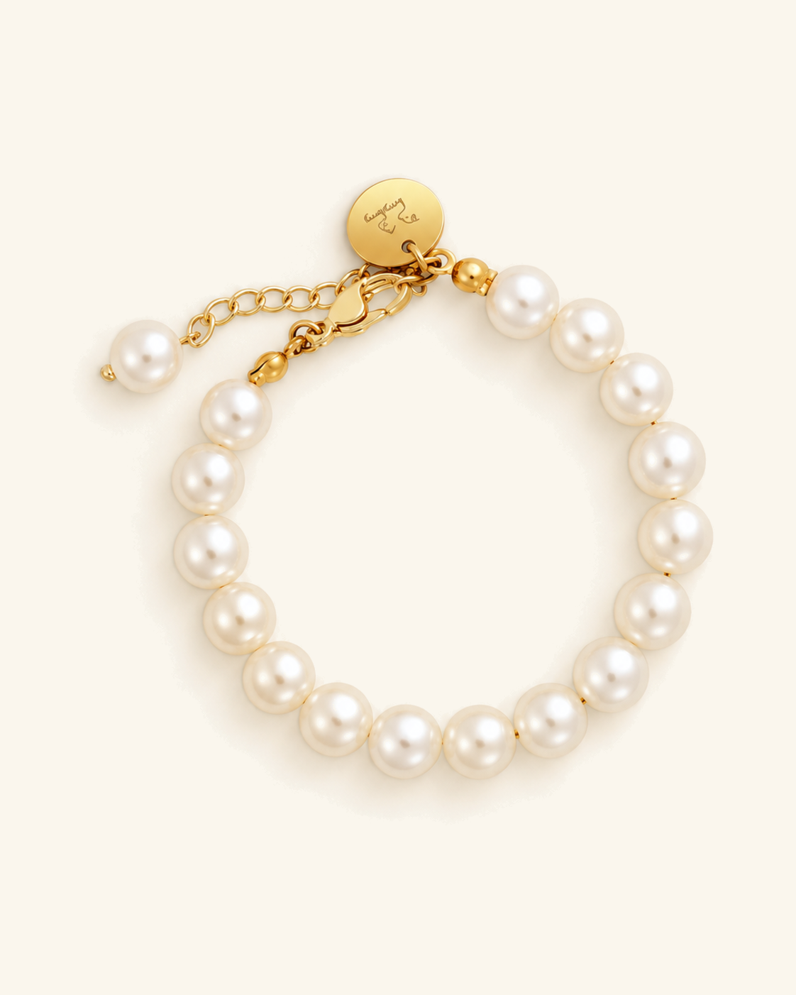 Faux pearl bracelet with a gold clasp and engraved tag