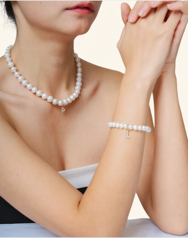 Woman wearing a faux pearl bracelet and matching pearl necklace