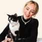 Woman and her tuxedo cat wearing matching faux pearl necklaces with bow charms