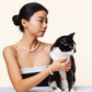 Woman and her tuxedo cat wearing matching freshwater pearls