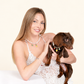 Woman holding her dachshund, both wearing matching freshwater pearl necklaces